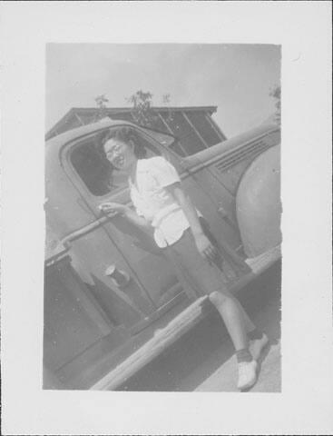 [Young woman in eyeglasses holding onto door handle of truck, Rohwer, Arkansas]