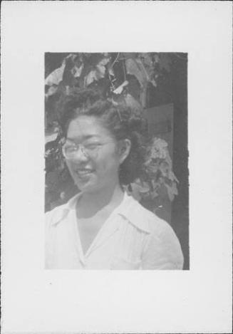 [Woman in eyeglasses in front of vines, head and shoulder portrait, Rohwer, Arkansas]