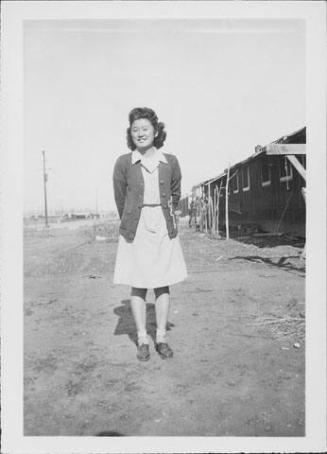 [Young woman wearing letterman sweater, full-length portrait, Rohwer, Arkansas, January 29, 1944 or 1945]