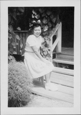 [Young woman sitting in front of porch, Rohwer, Arkansas, October 31, 1944]