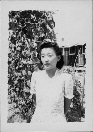 [Woman in spiral patterned dress in front of vines, half-portrait, Rohwer, Arkansas, July 9, 1944]