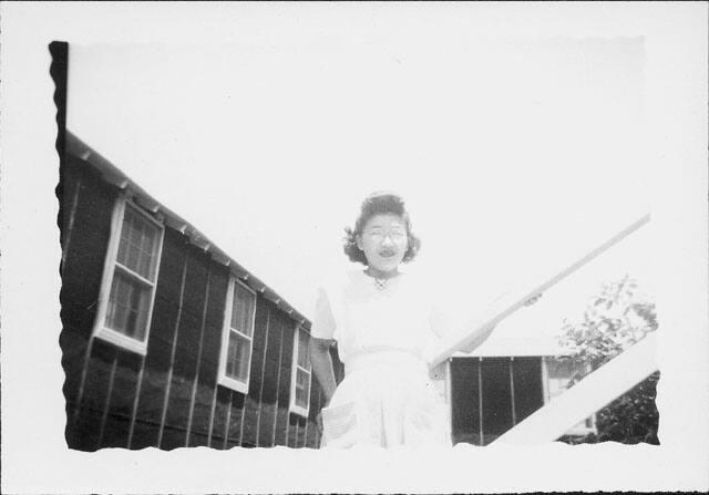 [Young woman in candy striper apron next to railing, Rohwer, Arkansas, July 29, 1944]