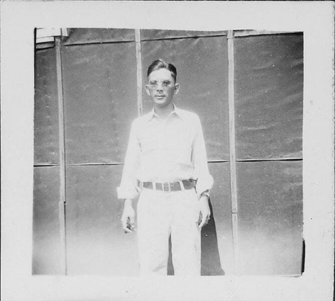 [Man in glasses standing in front of tarpapered barracks, Rohwer, Arkansas, June 9, 1944]
