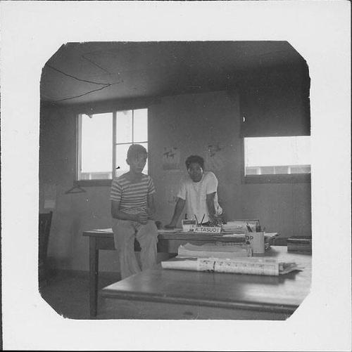 [Boy and man at K. Tasugi's desk, Rohwer, Arkansas, 1942-1945]