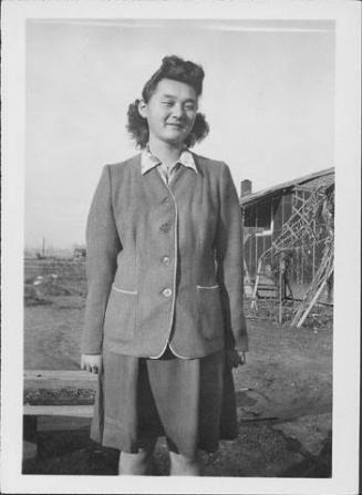 [Misako Nakatsuru in suit standing near barracks, Rohwer, Arkansas, January 29, 1945]