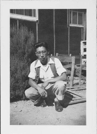 [Young man in vest crouching with cigarette, Rohwer, Arkansas, October 10, 1944]