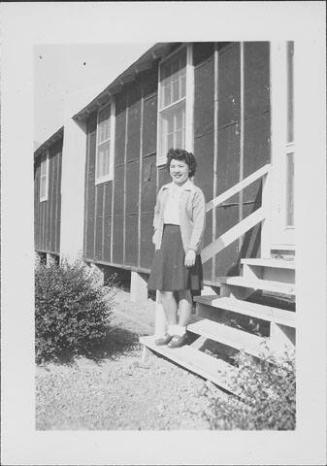 [Young woman standing on barracks steps, Rohwer, Arkansas]