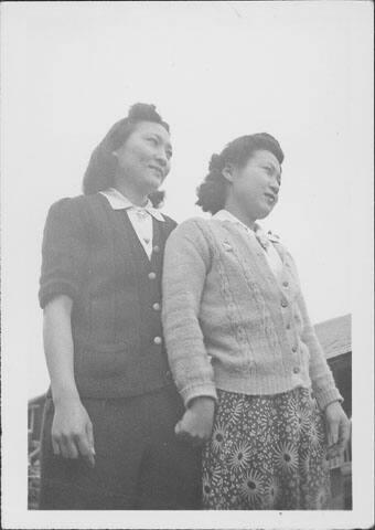 [Two women stand in profile outdoors, half-portrait, Rohwer, Arkansas]