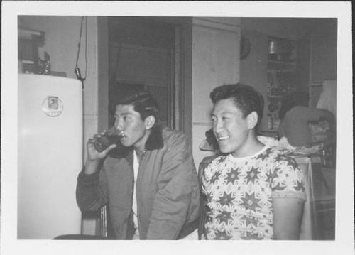 [Two young men, one drinking from glass, in a kitchen, United States, 1948]