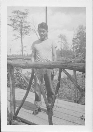[Man in t-shirt and jeans on wooden bridge, Rohwer, Arkansas, 1942-1945]
