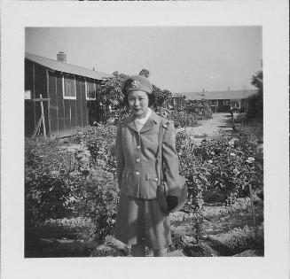 [Woman in United States Cadet Nurse Corps uniform standing in garden, partial portrait, Rohwer, Arkansas, September 23, 1944]