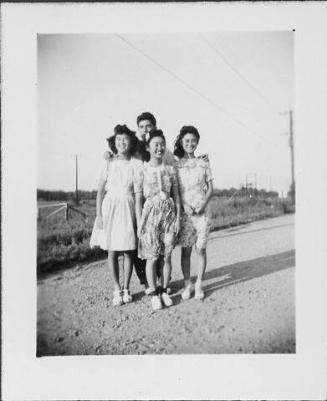 [Three young men and a young man standing unpaved road, Rohwer, Arkansas, October 28, 1944]