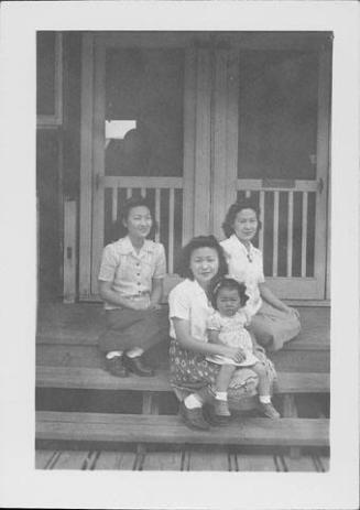 [Three women and little girl sitting on barracks porch steps, Rohwer, Arkansas, April 15, 1945]