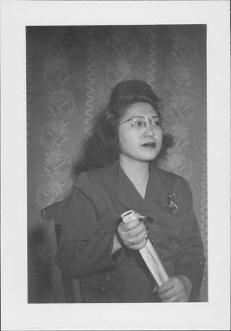 [Woman in eyeglasses and suit holding rolled papers, half-portrait Rohwer, Arkansas, April 12, 1945]