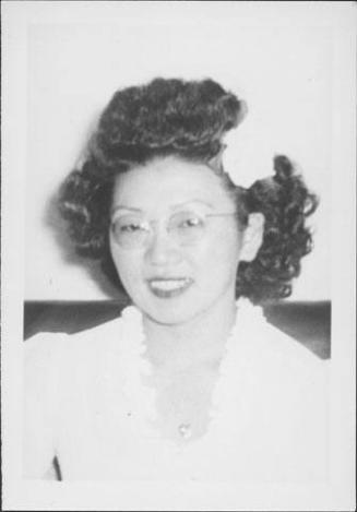 [Woman in eyeglasses and a white flower in hair, head and shoulder portrait, Rohwer, Arkansas, October 29, 1944]