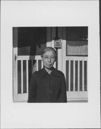 [Older woman with eyeglasses in front of barracks, half-portrait, Rohwer, Arkansas]