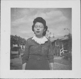 [Woman with eyeglasses and ruffled collar standing outdoors, half-portrait, Rohwer, Arkansas, November 10, 1944]