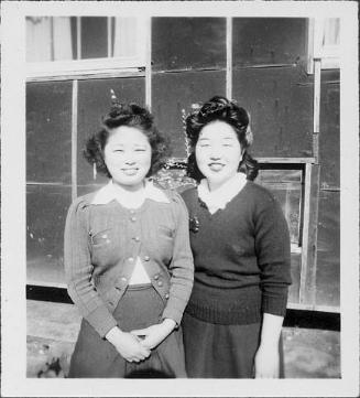 [Two women in sweaters in front of barracks, half-portrait, Rohwer, Arkansas, May 1945]