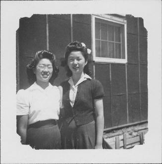 [Two women standing in front of barracks wall, half-portrait, Rohwer, Arkansas]