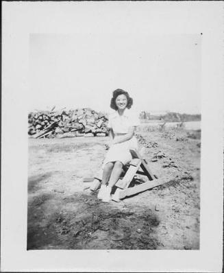 [Woman sitting on sawhorse, Rohwer, Arkansas, June 6, 1945]