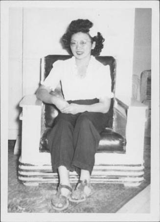 [Woman in eyeglasses and white flower in hair, seated portrait, Rohwer, Arkansas, October 29, 1944]