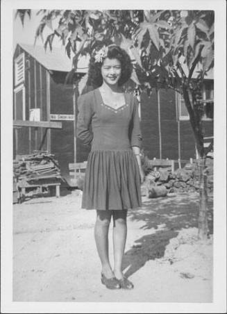 [Young woman in short dress with sweethart neckline and flower in hair, full-length portrait, Rohwer, Arkansas, October 16, 1944]
