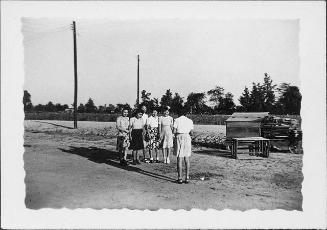 [Five young women face another woman on dirt road, Rohwer, Arkansas]