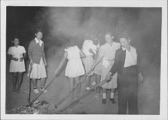 [Women and girls roasting food on sticks, Rohwer, Arkansas, September 9, 1944]