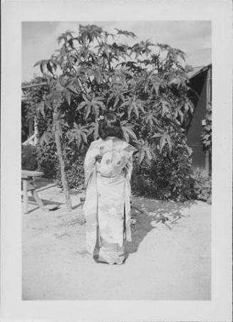 [Young woman in kimono standing with back to viewer, Rohwer, Arkansas]
