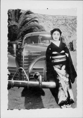 [Woman in montsuki kimono leaning on Plymouth automobile, Rohwer, Arkansas]