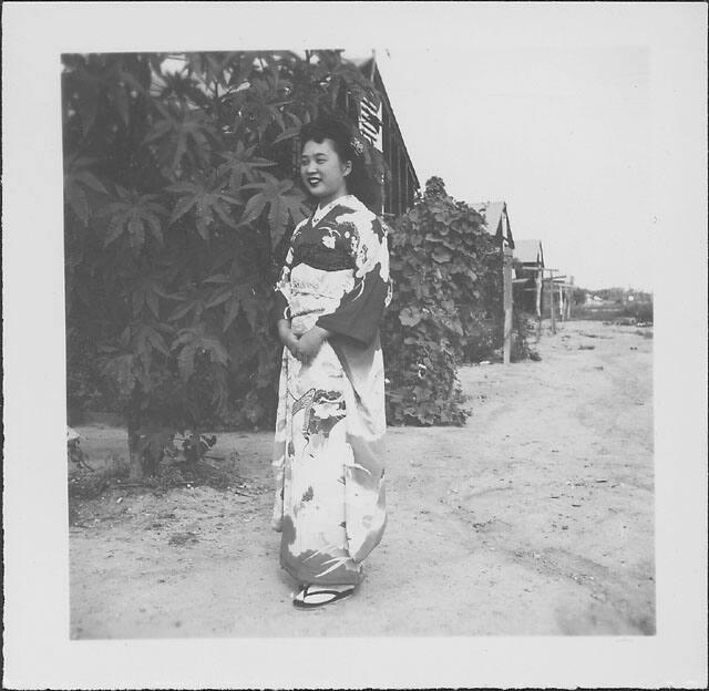 [Young woman in kimono standing in front of tree and barracks, Rohwer, Arkansas, September 13, 1944]