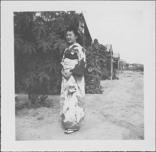 [Young woman in kimono standing in front of tree and barracks, Rohwer, Arkansas, September 13, 1944]