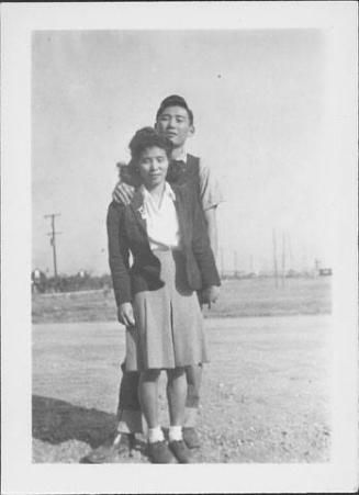 [Couple standing in open graveled area, Rohwer, Arkansas]
