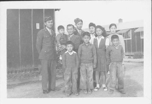 [Two United States Army soldiers with large family in front of barracks, Rohwer, Arkansas, November 21, 1944]