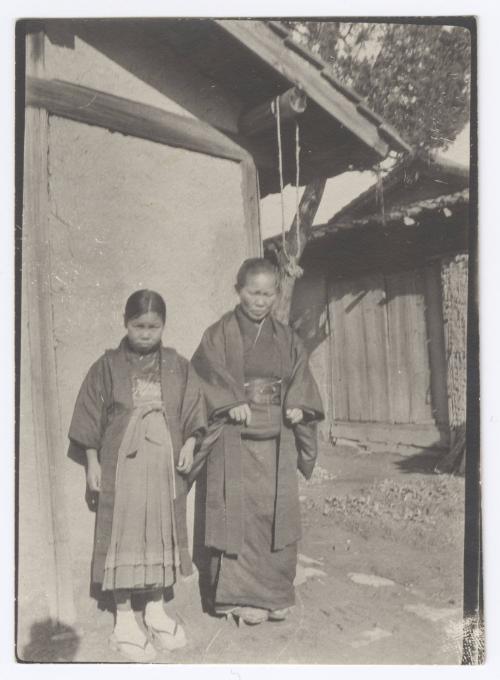 [Woman and girl in kimono standing outside of building, Japan]