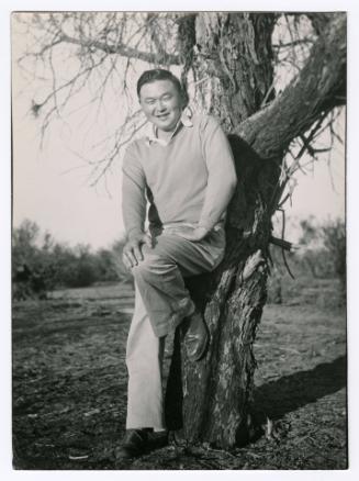 Man leaning on tree