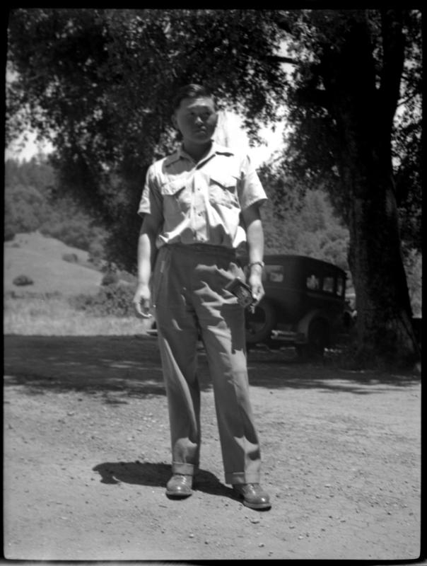 Man standing in front of tree and car