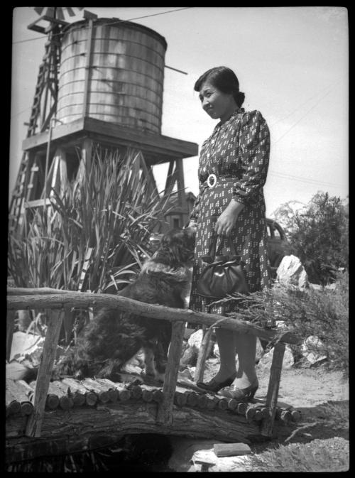 Tama Miwa with dog on a garden bridge