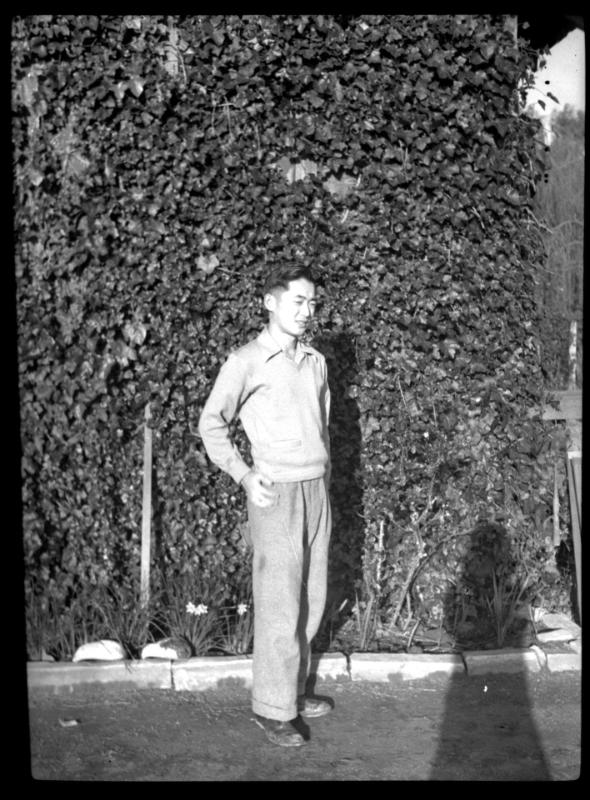 Man standing in front of ivy-covered wall