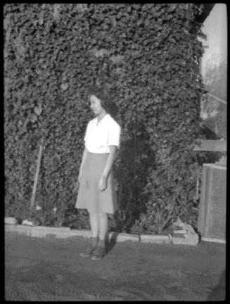 Mae Miwa standing for photo in front of ivy-colored wall
