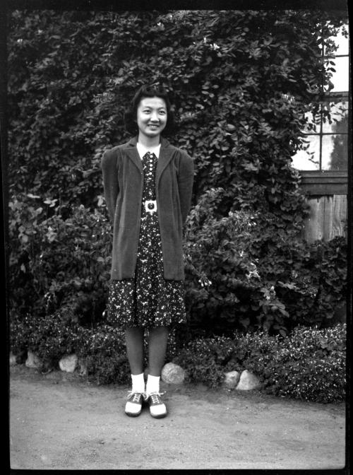 Mae Miwa in front of ivy-covered wall