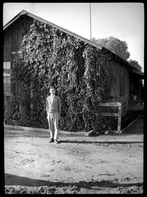 Young man in front of ivy-covered building