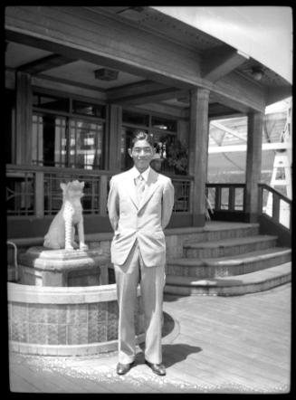 Joe Kuramoto in front of Asian-style building and fountain