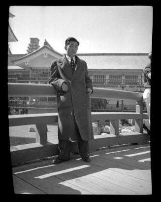 Man in coat in front of Japanese building at Golden Gate International Exposition