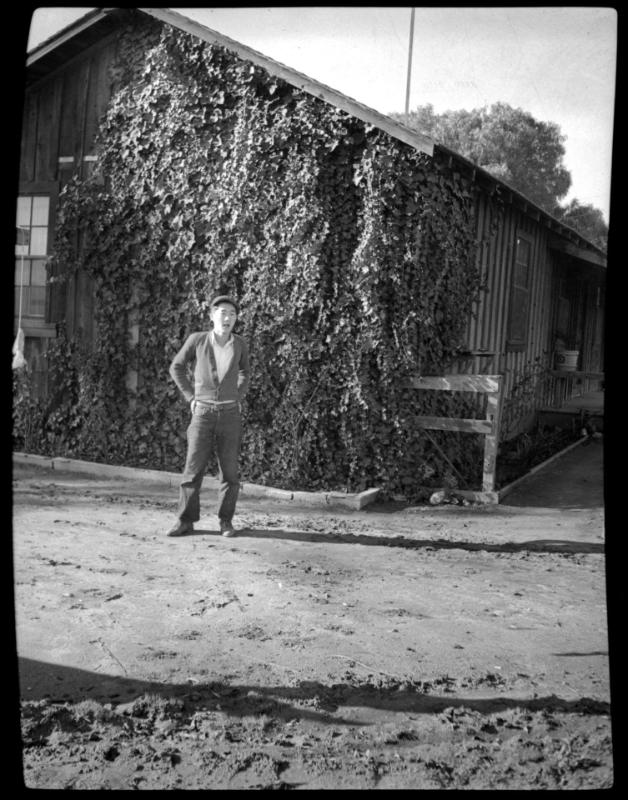 Young man in front of ivy-covered building