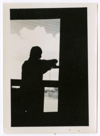 Silhouette of a man looking outside