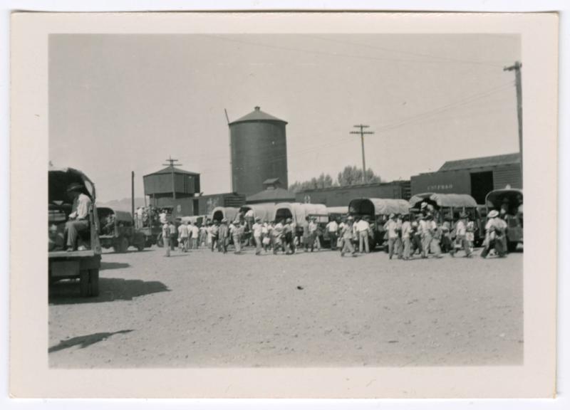 People loading into the beds of trucks