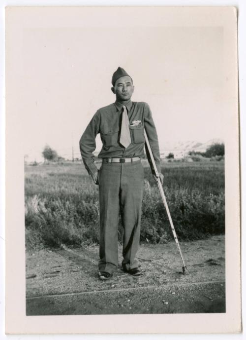 Unidentified military man standing on dirt road