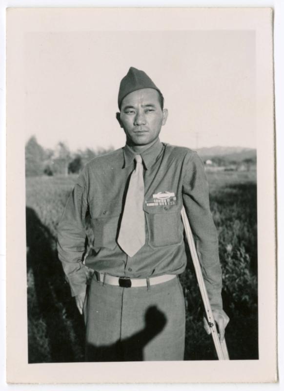 Unidentified military man standing on dirt road