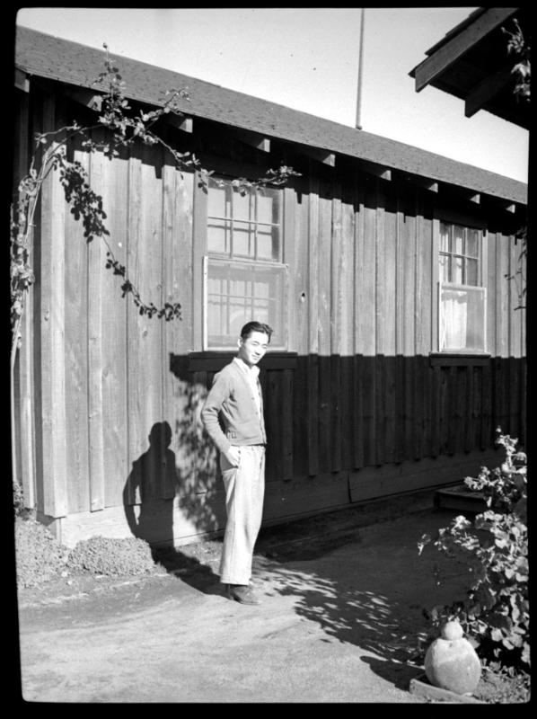 Young man in front of wooden building